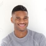 30992744 portrait of a cool young black man smiling with arms crossed on white background 30992744 portrait of a cool young black man smiling with arms crossed on white background